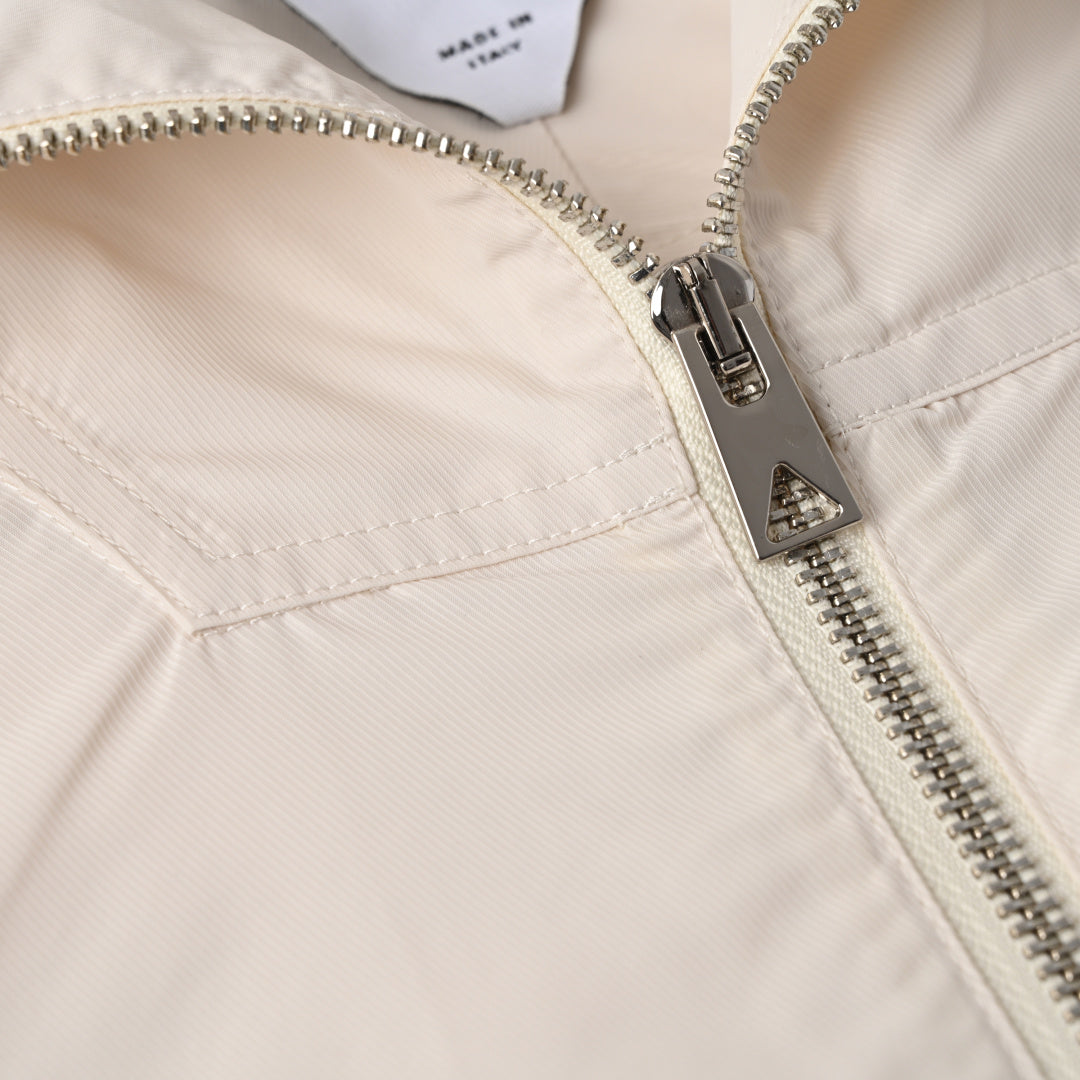 Off-white hooded jacket with silver zipper and zip pull close-up