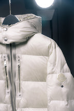 White Moncler puffer jacket with hood, zipper front, and chest pocket detail