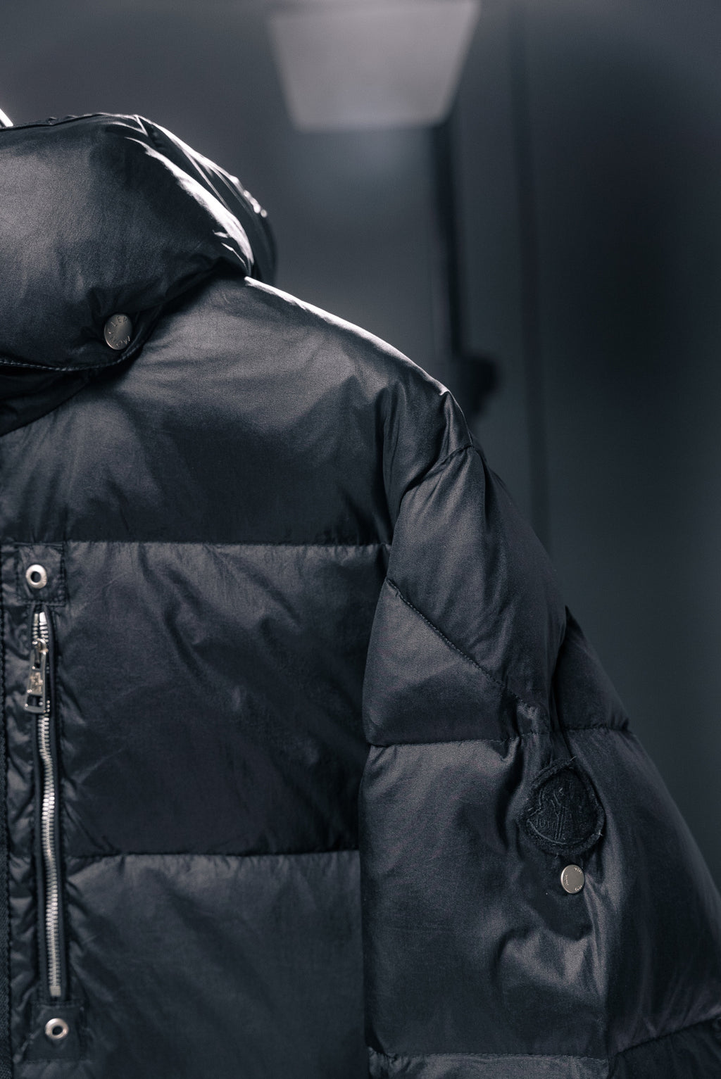 Moncler puffer jacket shoulder and sleeve detail with snap buttons, dark fabric