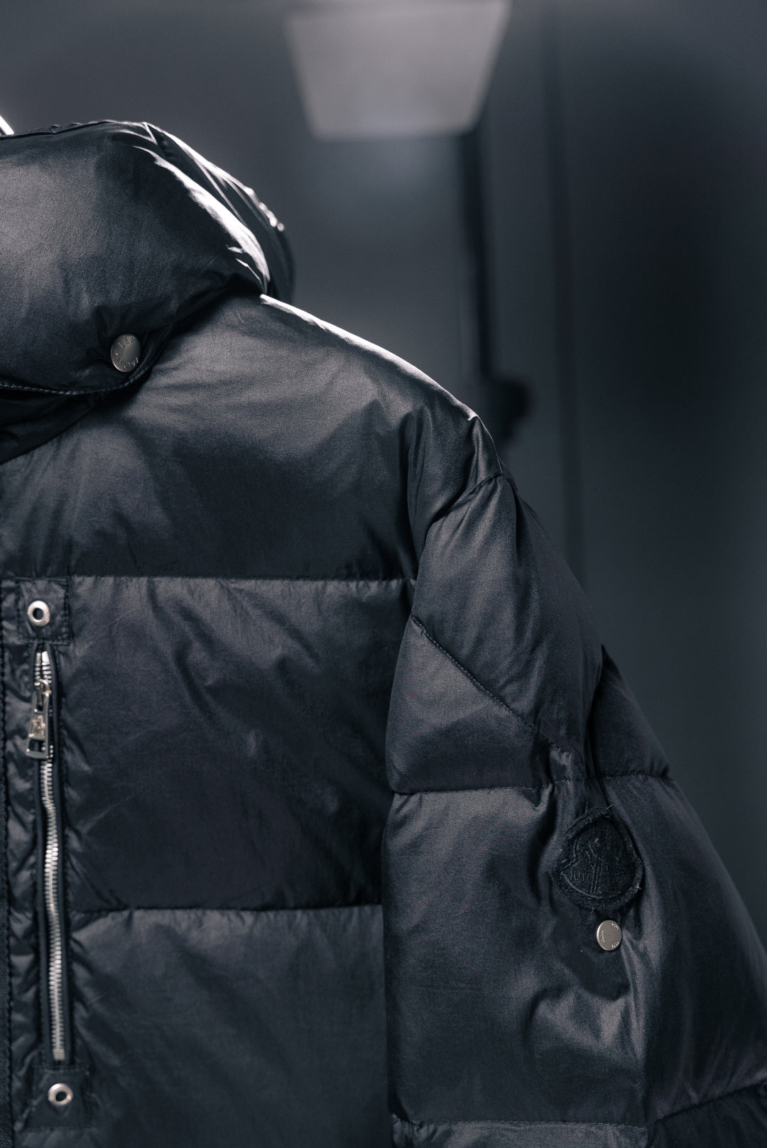 Moncler puffer jacket shoulder and sleeve detail with snap buttons, dark fabric