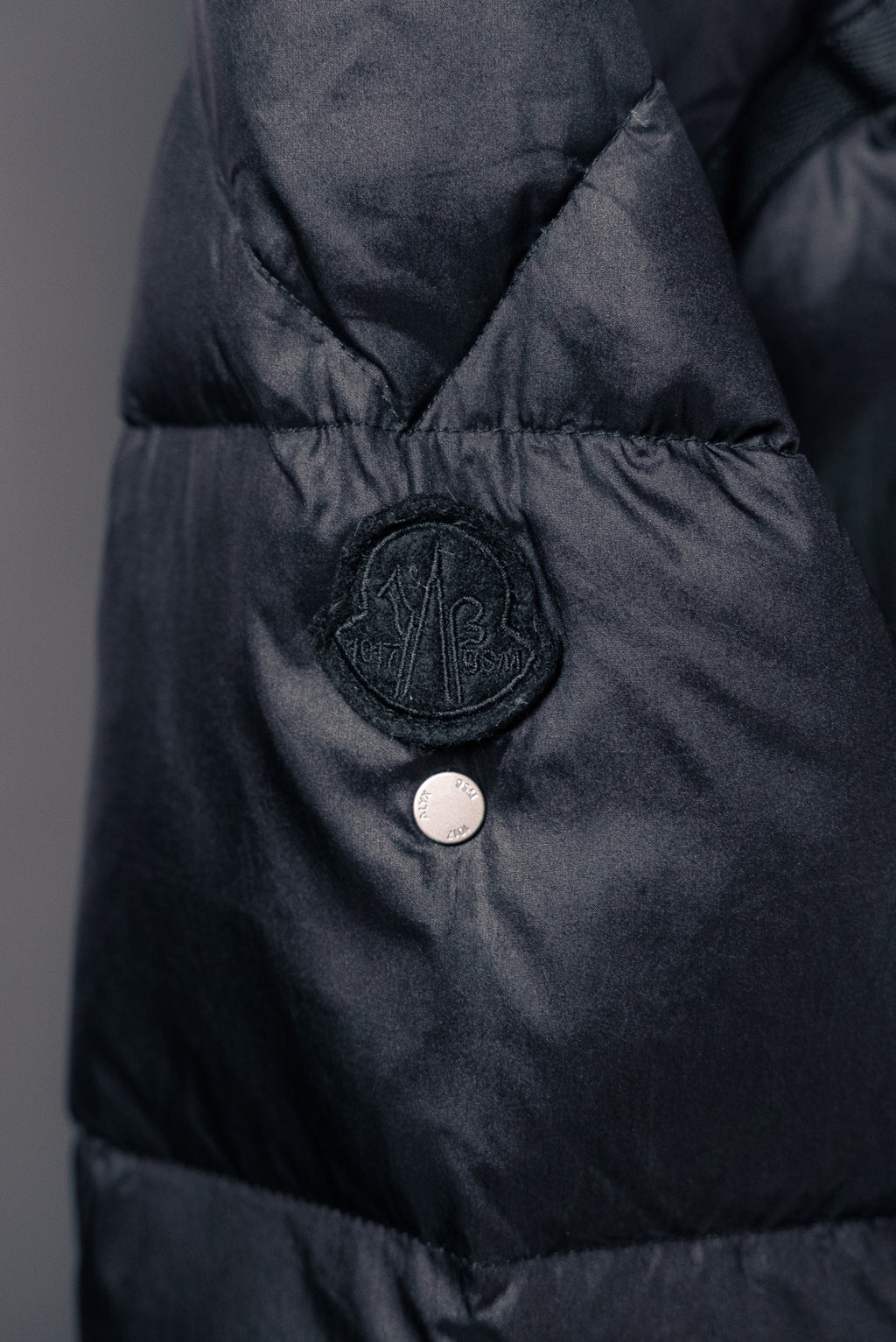 Moncler puffer jacket chest snap button and circular logo badge