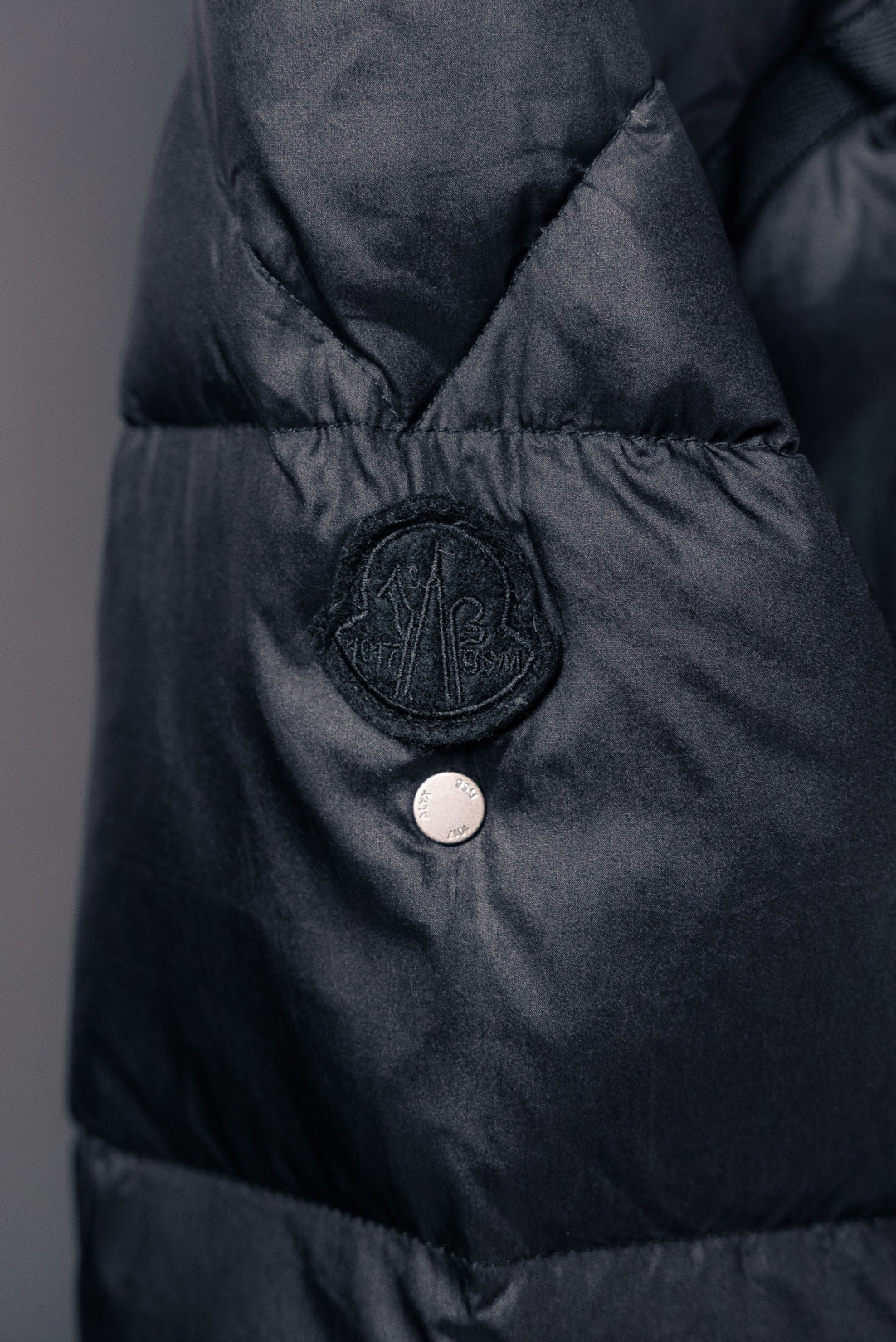 Moncler puffer jacket chest snap button and circular logo badge