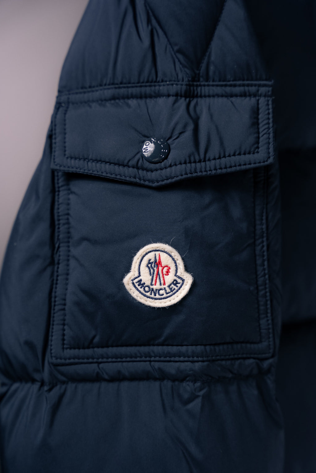 Moncler long puffer jacket chest patch pocket with snap tab and logo badge