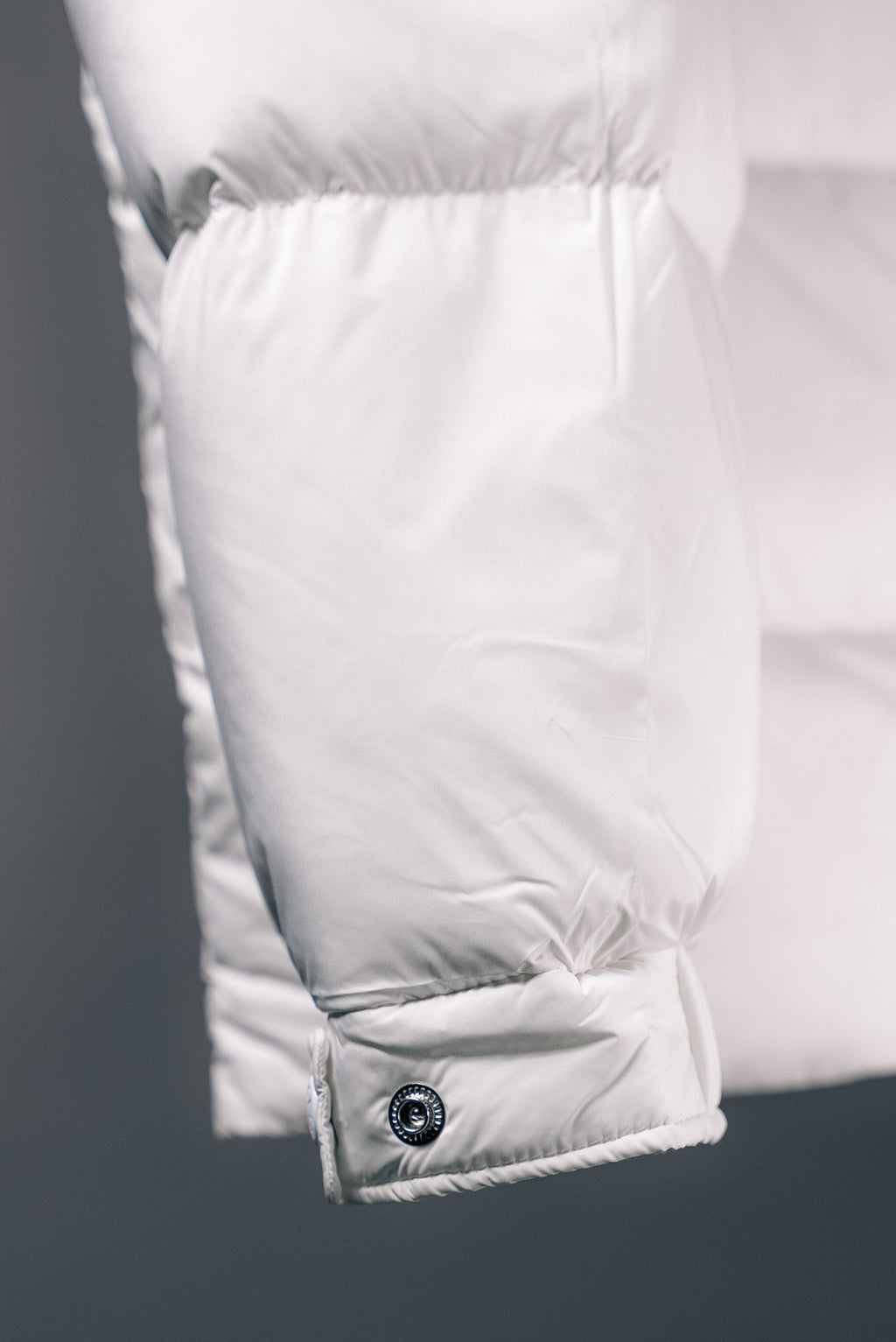 White puffer jacket lower hem with buttoned pocket flap