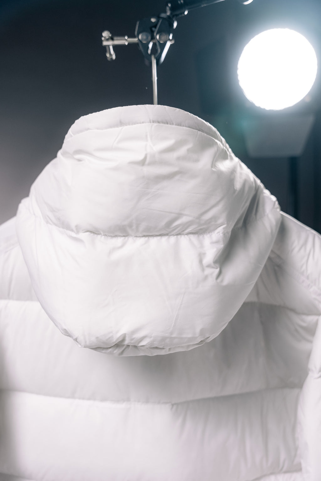 White puffer jacket hood with high collar and quilted shoulder panels