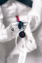 White puffer jacket sleeve cuff with snap button and hanging Moncler tag