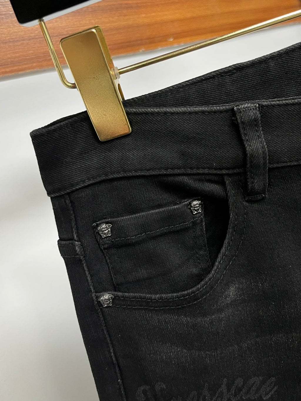 Black denim jeans with contrast pocket stitching and small Versace logo badge