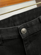 Black denim jeans waistband close-up with round logo button