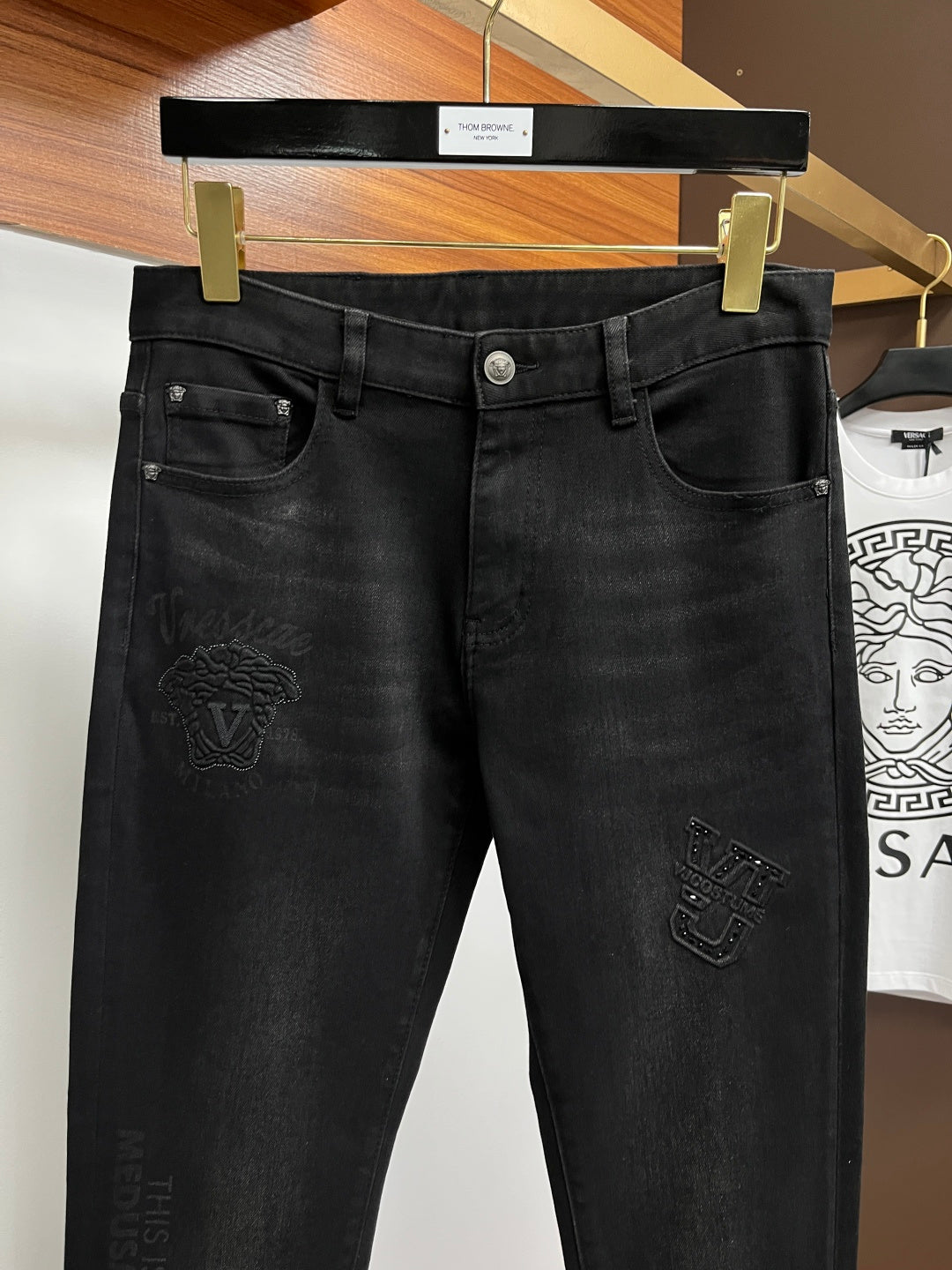 Black denim jeans with front pockets and subtle embroidered detailing