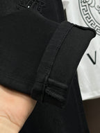 Black denim jeans leg close-up with stitched inner seam