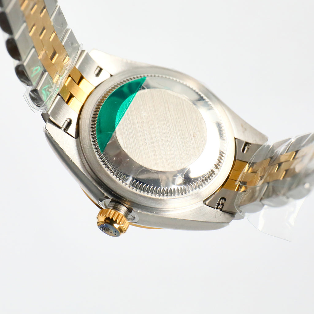 Two-tone wristwatch side view with crown and green-tinted cyclops lens