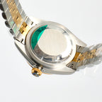 Two-tone wristwatch side view with crown and green-tinted cyclops lens