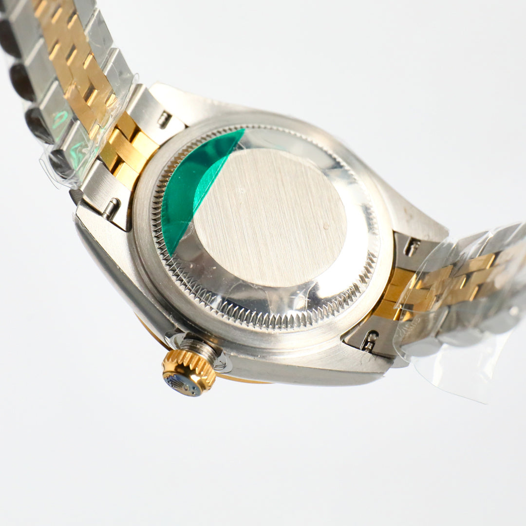 Two-tone wristwatch side view with crown and green-tinted cyclops lens