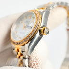 Two-tone wristwatch with diamond bezel, gold crown, and white dial