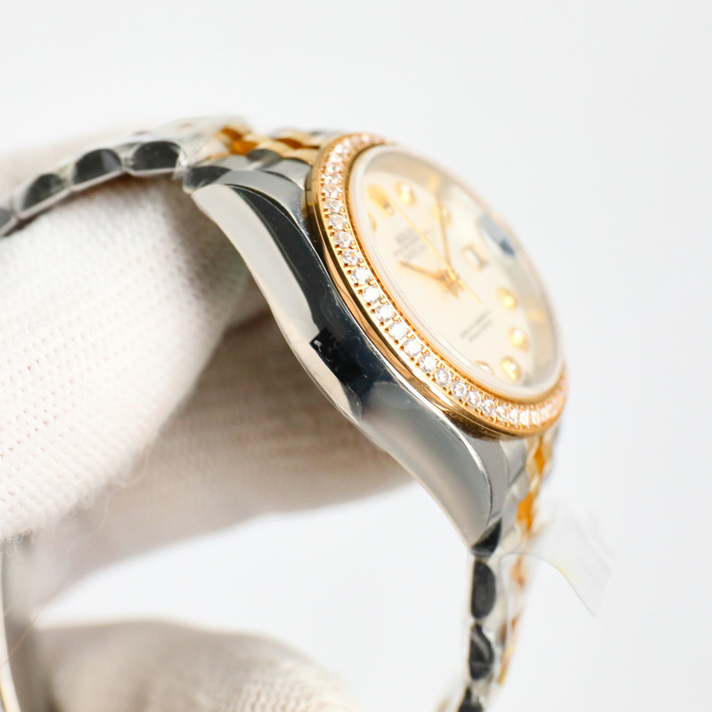 Two-tone wristwatch side profile with diamond bezel and gold trim