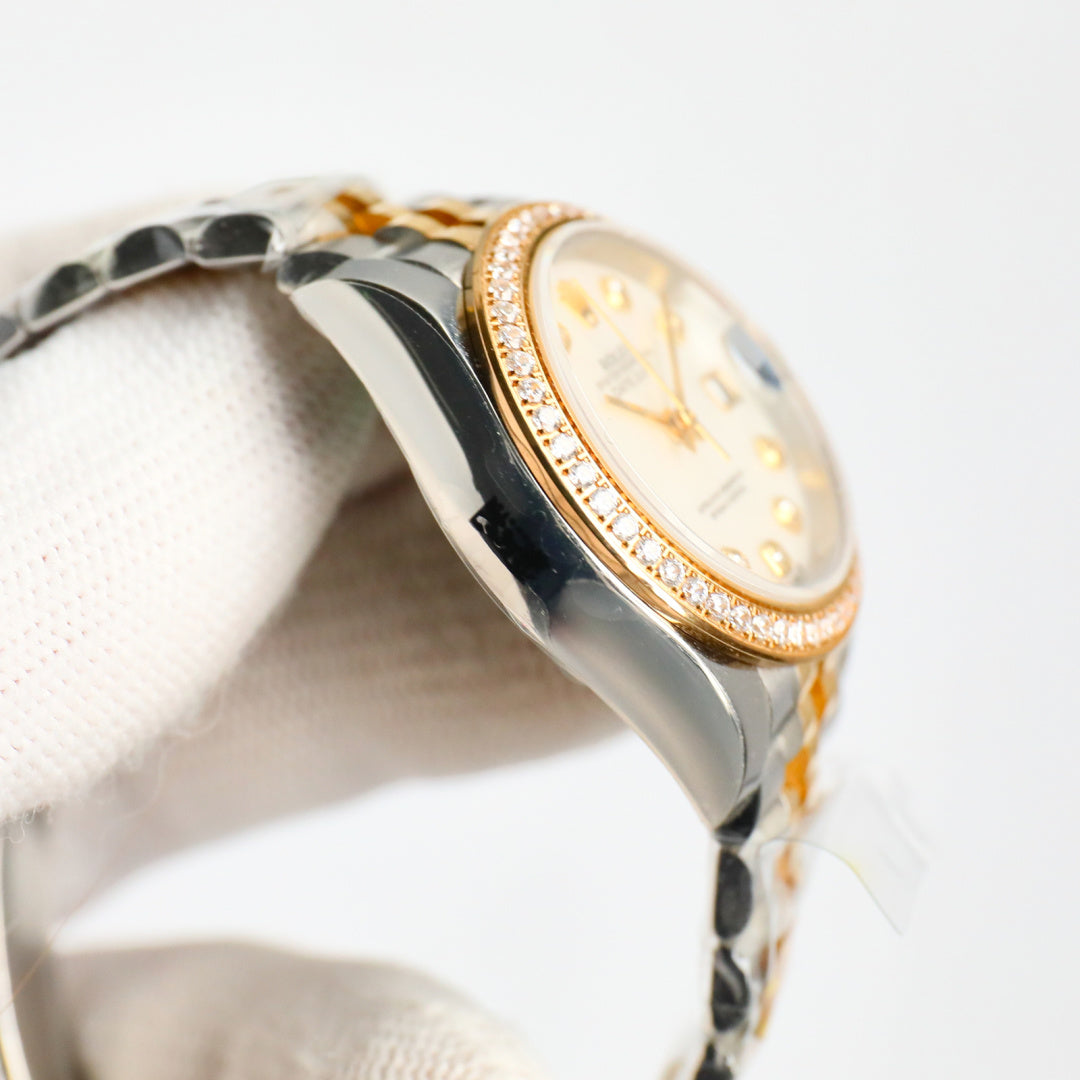 Two-tone wristwatch side profile with diamond bezel and gold trim