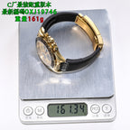 Rolex wristwatch on a digital scale, gold-tone case with black rubber strap.