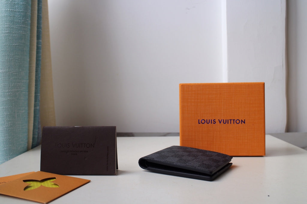 Dark checkered Louis Vuitton wallet lying flat on its side