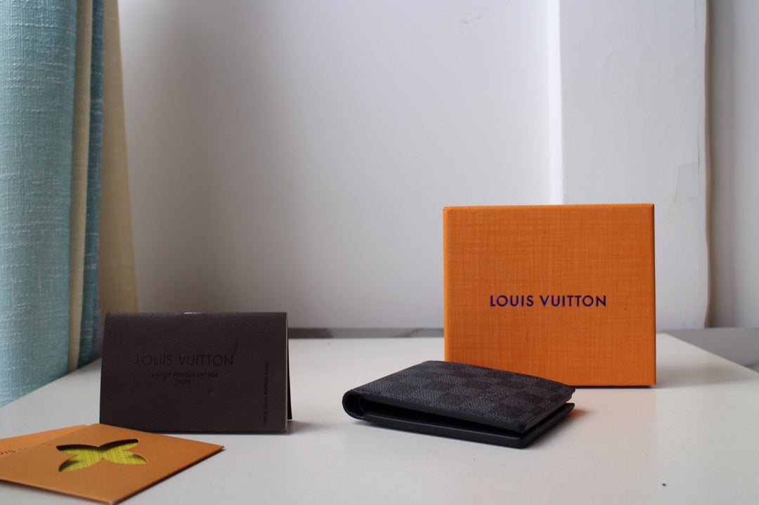 Dark checkered Louis Vuitton wallet lying flat on its side