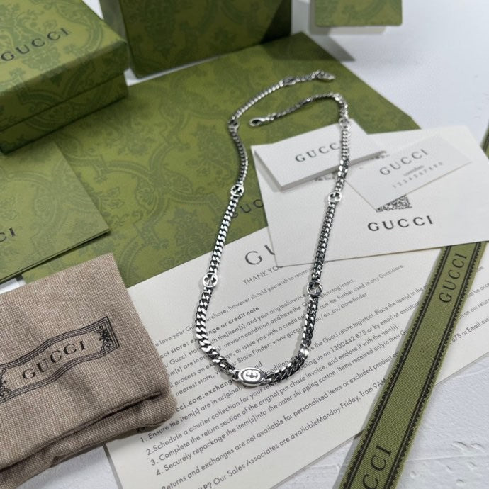 Silver-tone chain necklace with round pendant and lobster clasp