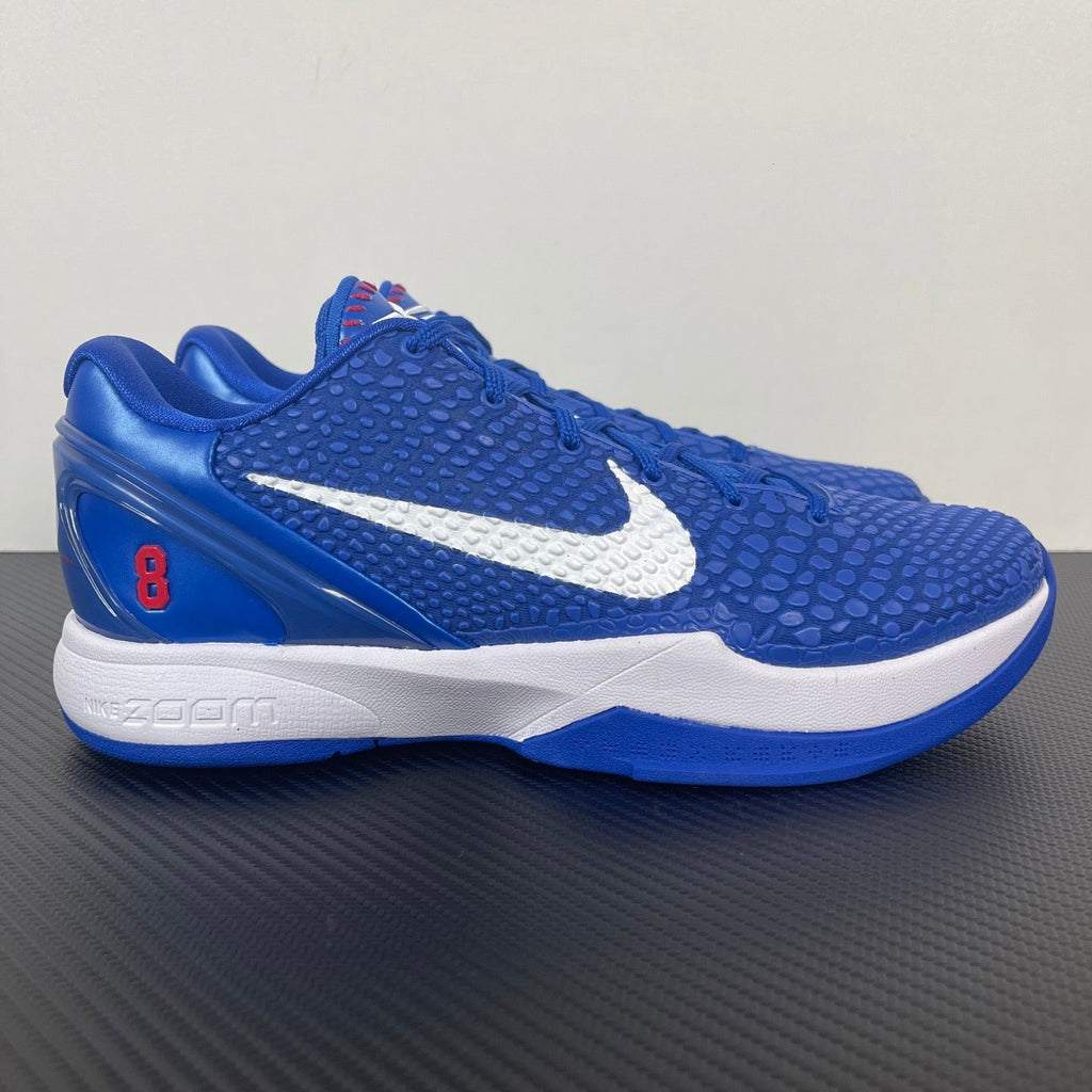 Blue Nike basketball sneaker with white swoosh and white midsole trim