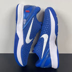 Blue Nike basketball sneaker side view with white heel panels and outsole tread