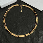 Gold chain collar necklace with small hanging charm and rectangular link details