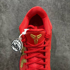 Red basketball shoe tongue and lace-up area with gold emblem and white pull tab