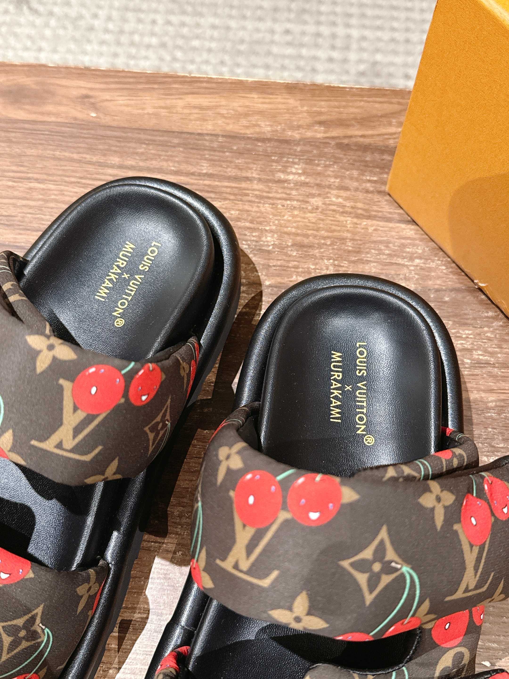 Louis Vuitton cherry-print slide sandals, close-up of black footbed with brand text
