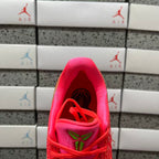 Red sneaker interior opening with red laces and green emblem detail