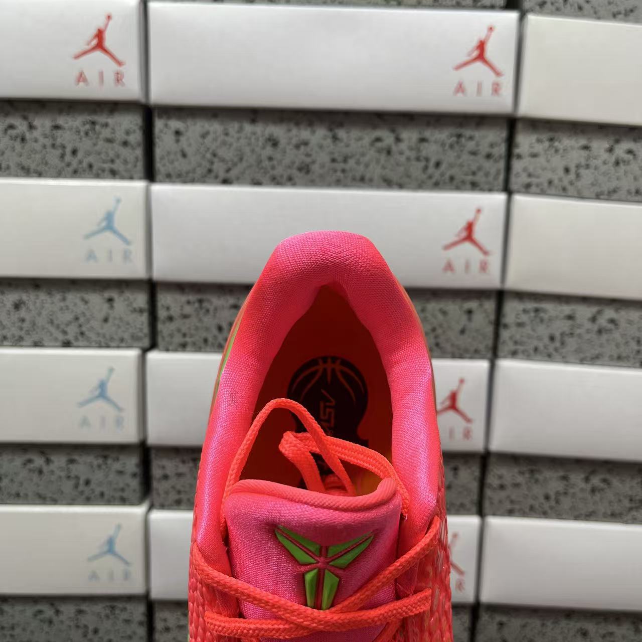 Red sneaker interior opening with red laces and green emblem detail