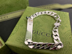 Silver chain bracelet with Gucci charm and white leather panel, shown from above