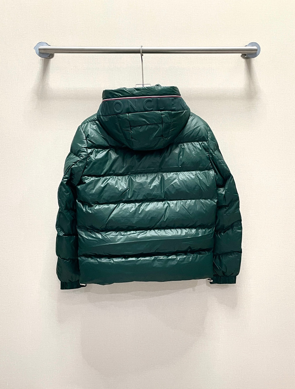 Moncler long puffer jacket, green back view with hood, on hanger