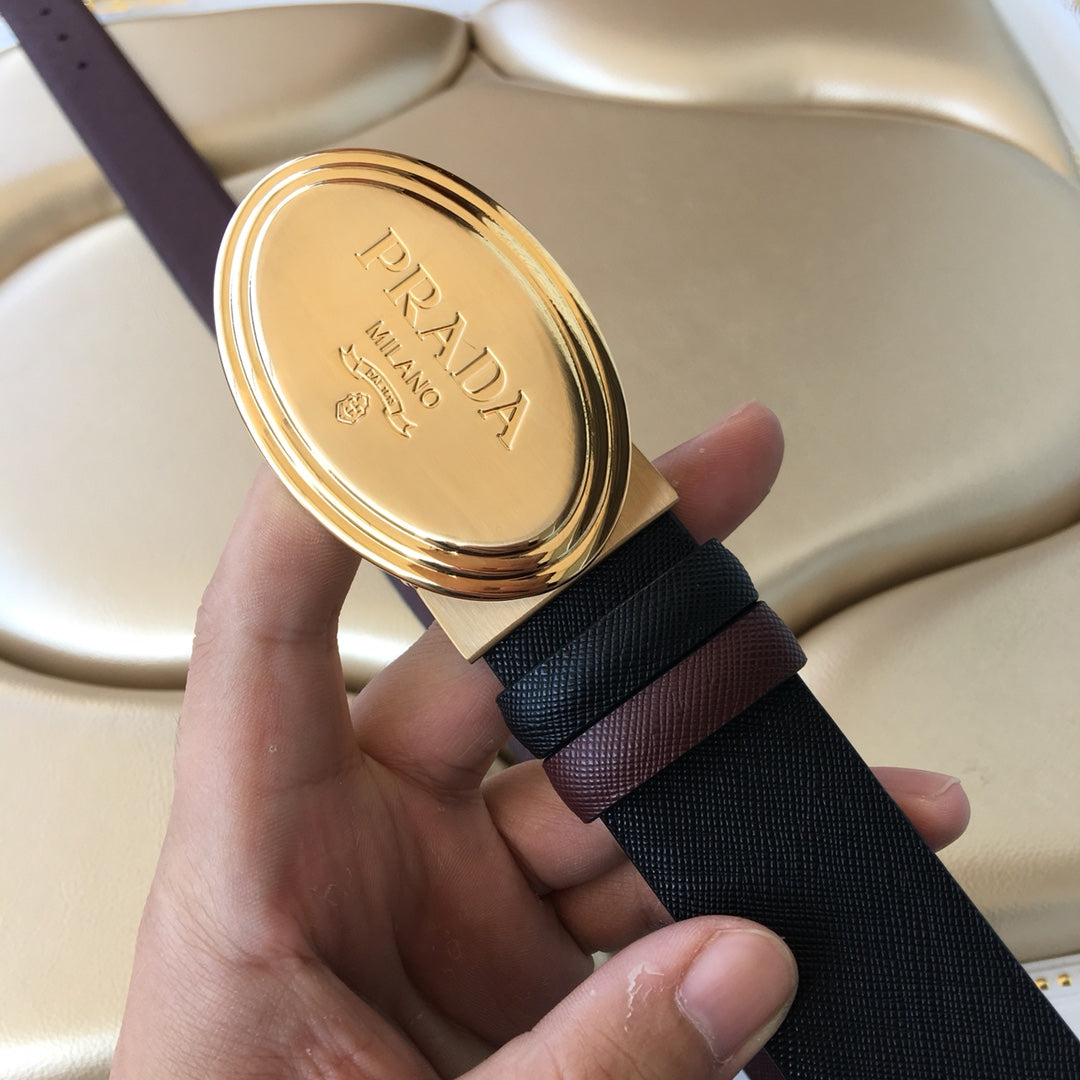 Prada belt close-up: gold oval PRADA MILANO buckle on dark strap.