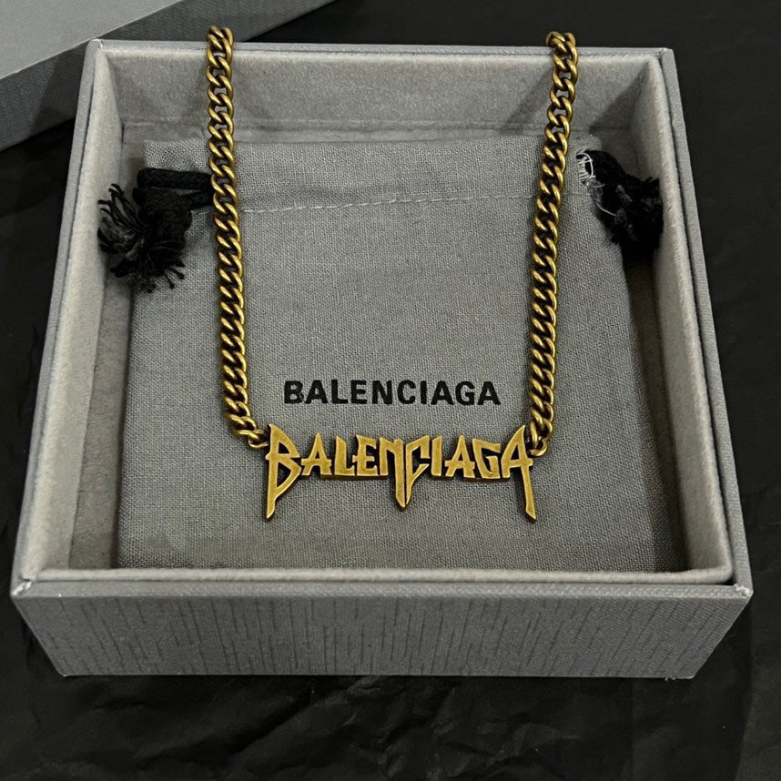 Balenciaga gold chain necklace inside gray gift box with branded tag and charms