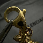 Balenciaga logo clasp detail on gold tone chain bracelet, with ring attachment
