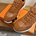 Brown suede lace-up sneakers close-up with grid stitching and white tread sole