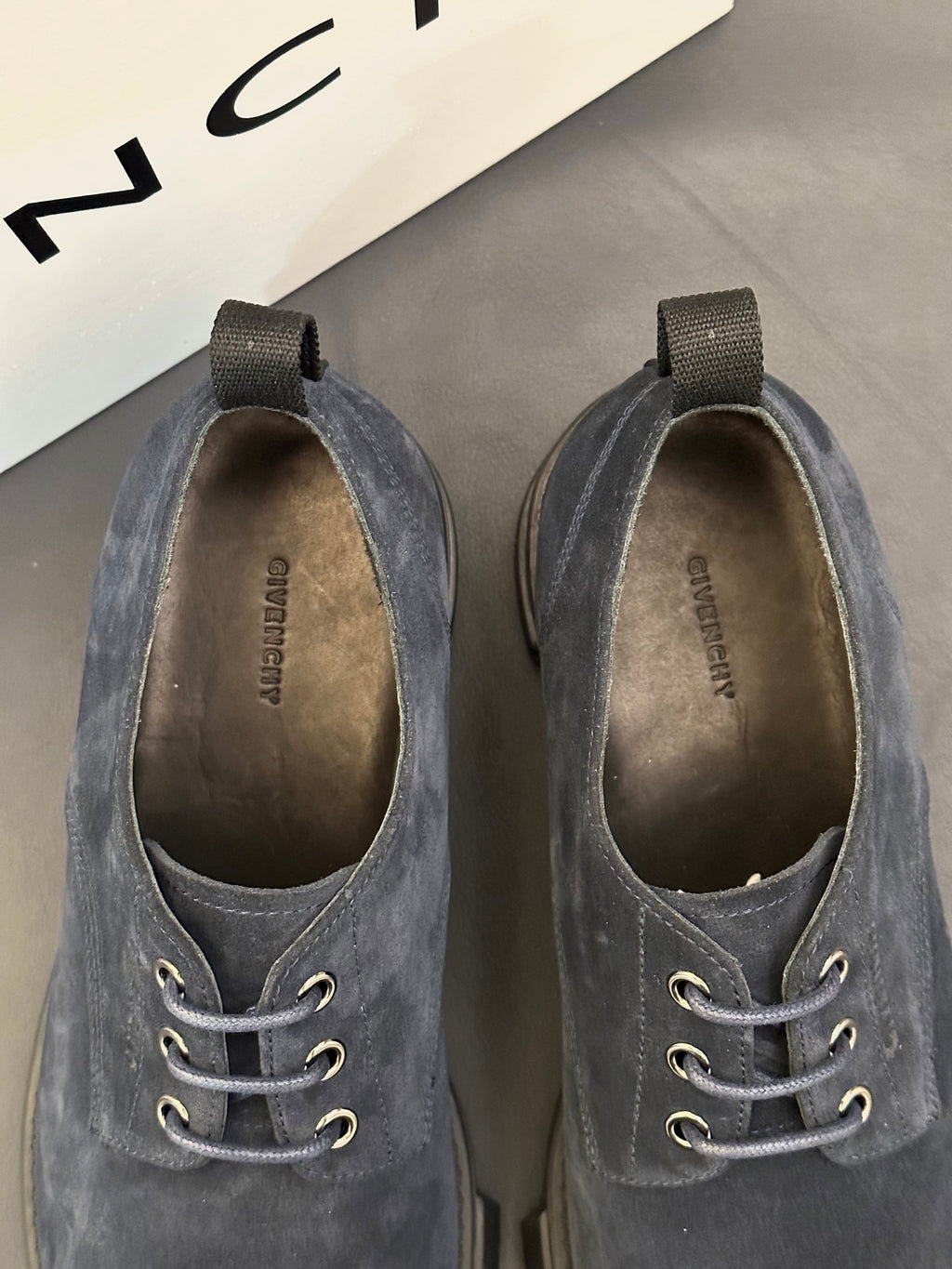 Navy suede shoes showing interior lining and lace-up eyelets detail