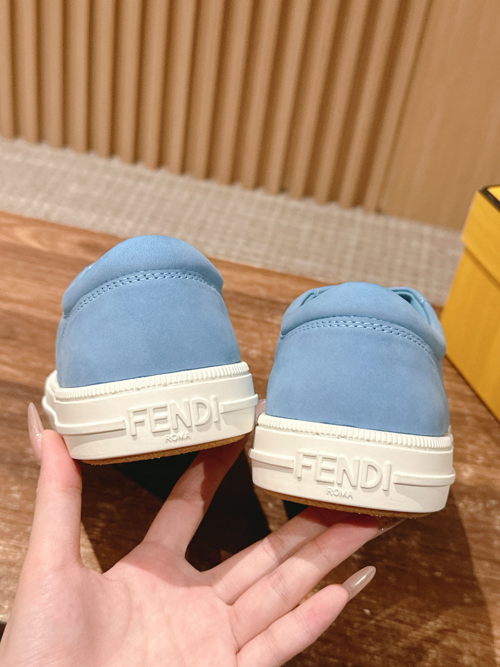 Light blue sneakers with FENDI logo on off-white heel tabs.