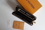 Louis Vuitton small bag opened to dark interior with multiple compartments and zip.