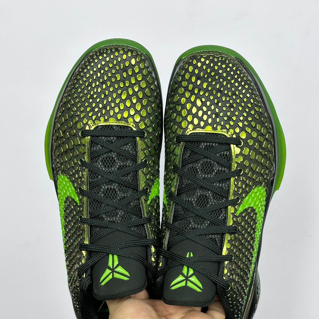 Pair of black and green basketball shoes with textured upper and black laces.