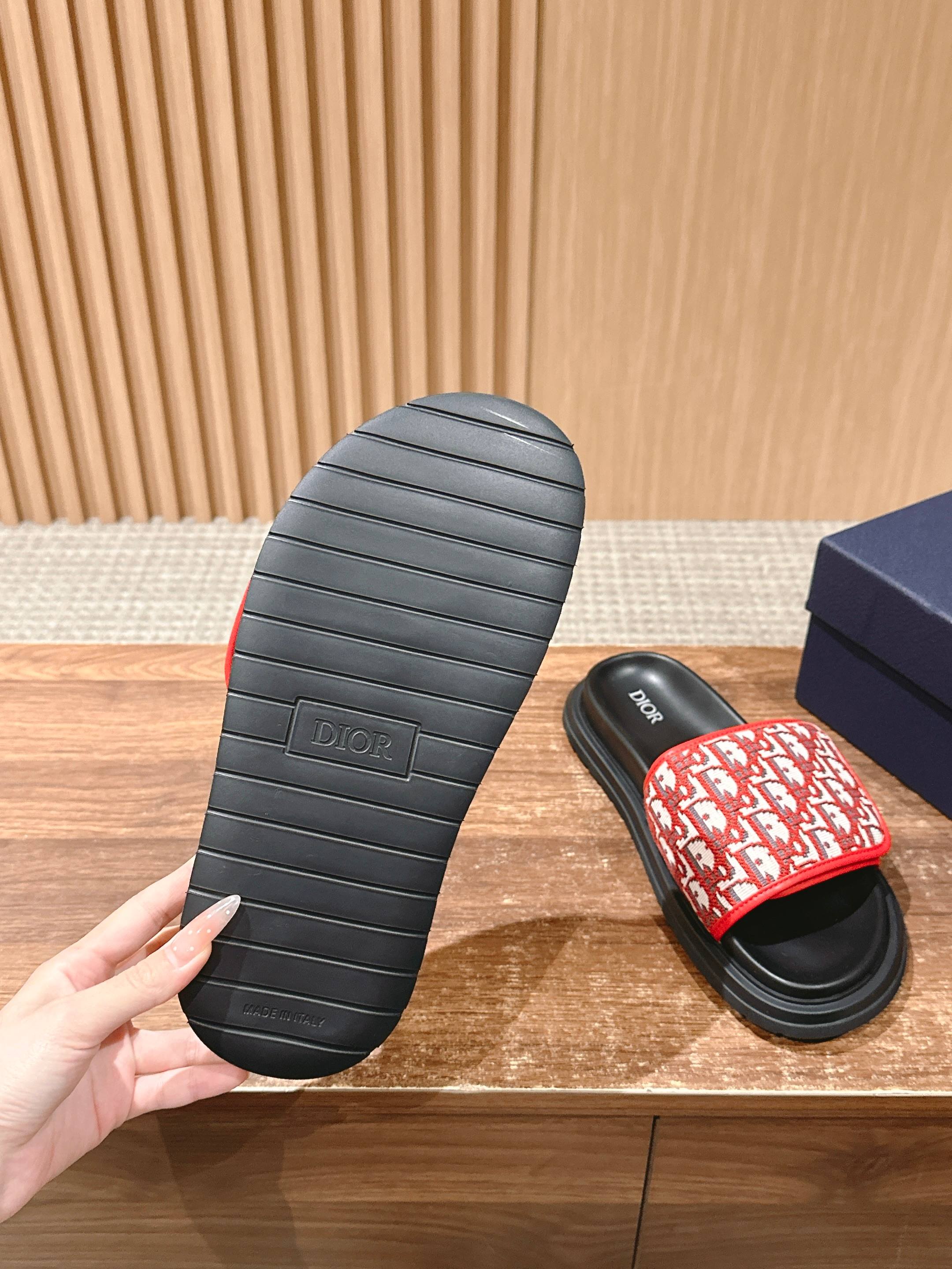 Dior slide sandal outsole view, black rubber sole with red patterned upper