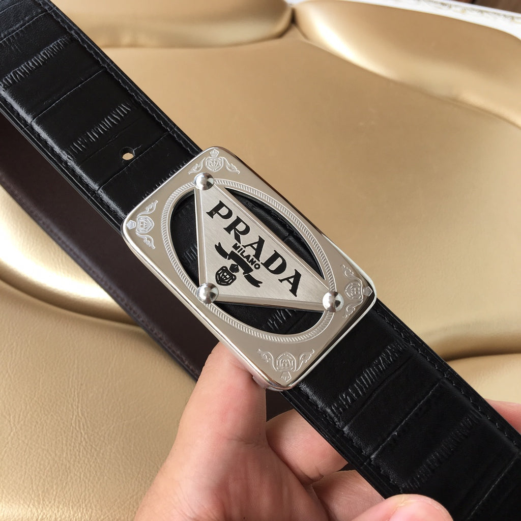 Prada belt close-up: dark leather strap with silver logo plaque buckle