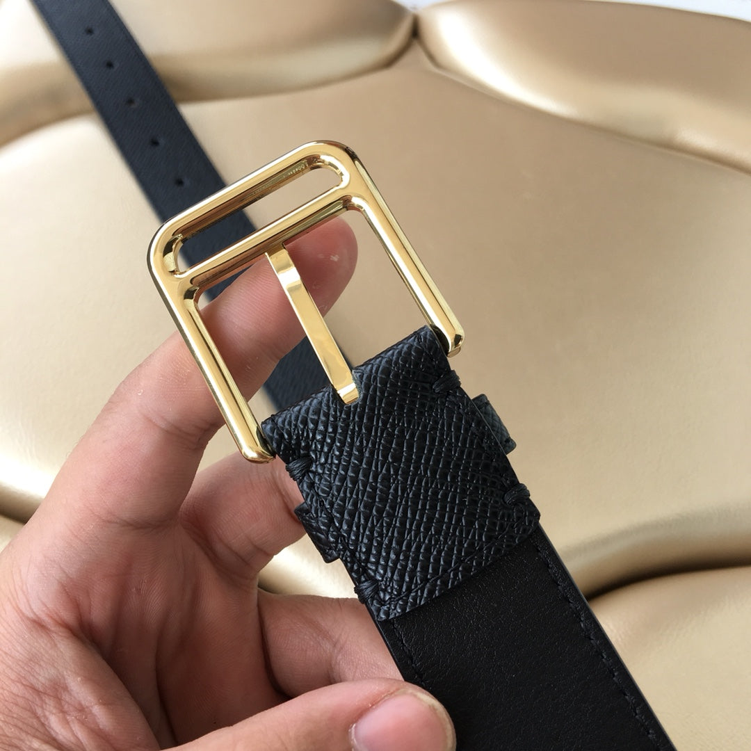 Dark leather belt close-up of gold buckle with prong detail