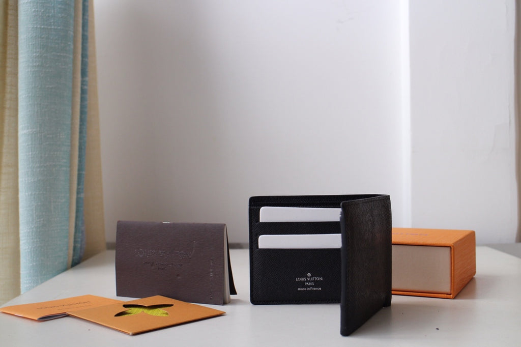Louis Vuitton small black textured leather card pouch open, showing interior card holders
