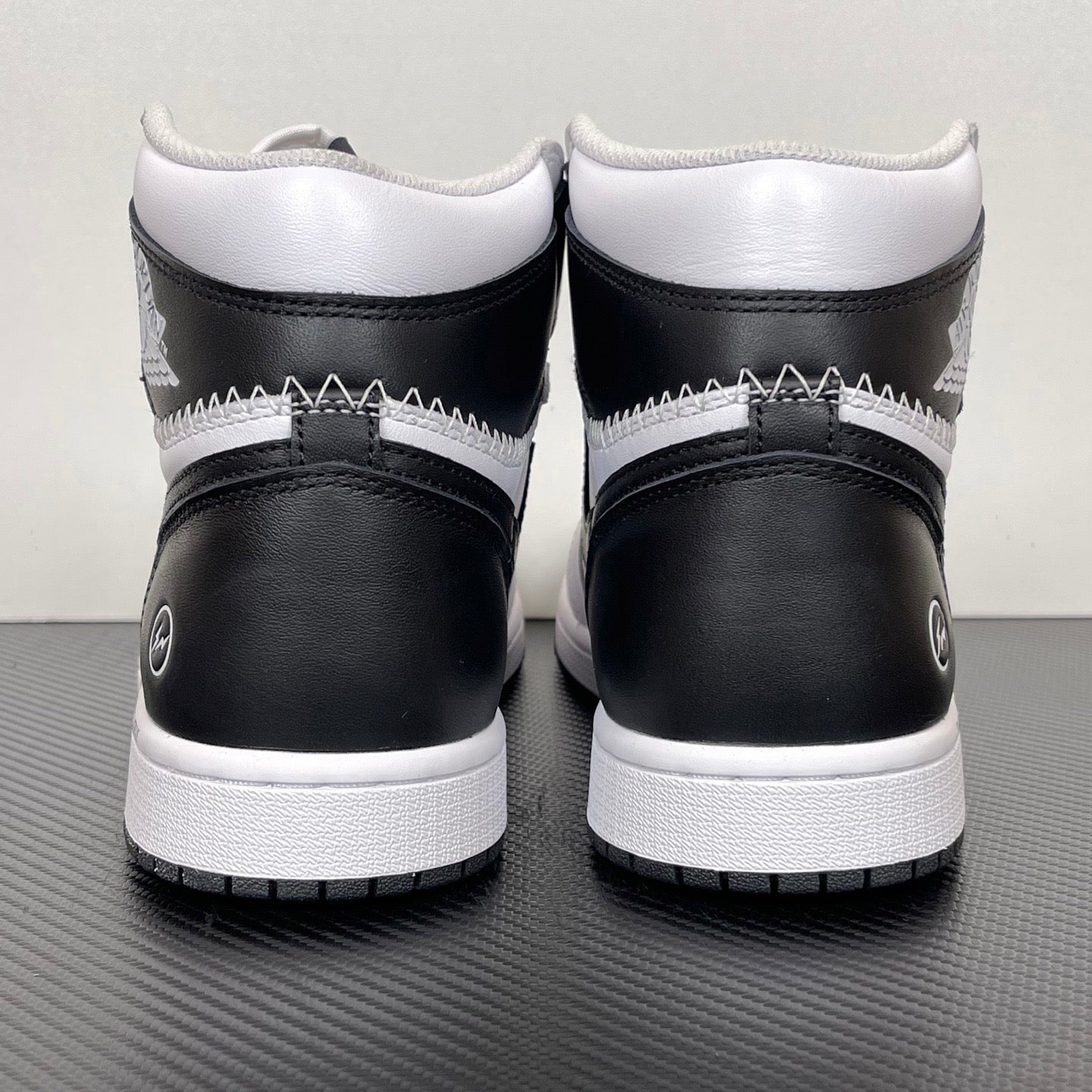 Pair of white and black high-top sneakers with black heel panels and white midsole
