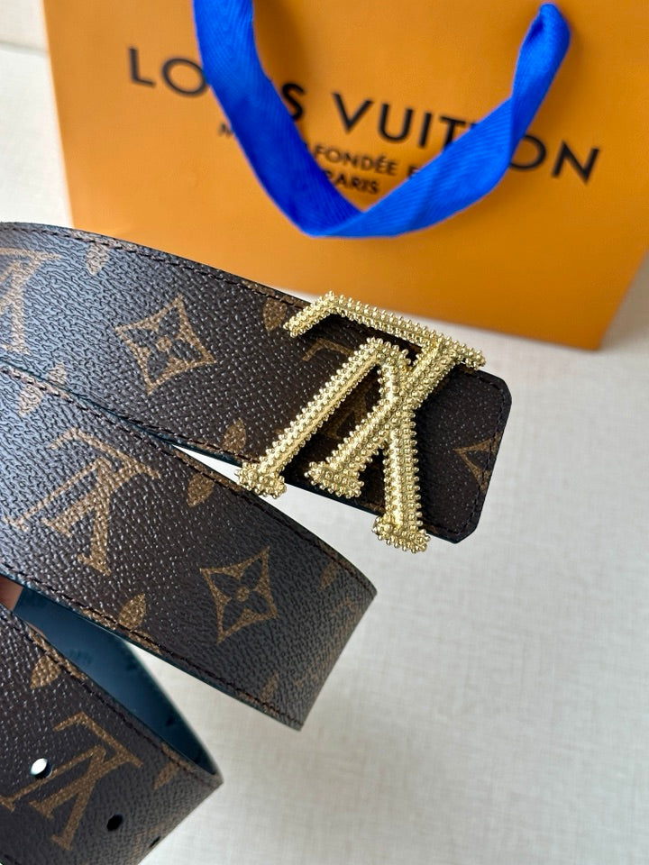 Dark monogram belt with gold buckle and diamond-like stud border