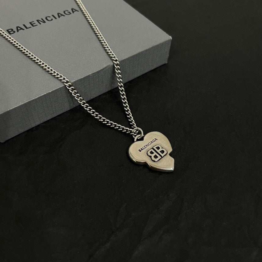 Heart pendant necklace with silver chain and heart charm, shown on black surface