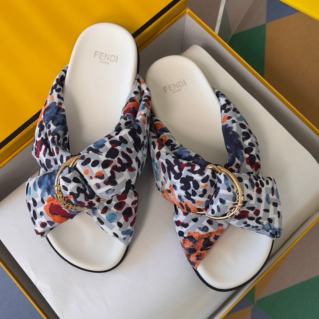 Fendi slide sandals pair with multicolor leopard-print straps and gold-tone buckle on white footbeds