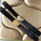 Two Prada belts laid out: navy textured straps with burgundy accents and oval gold buckles